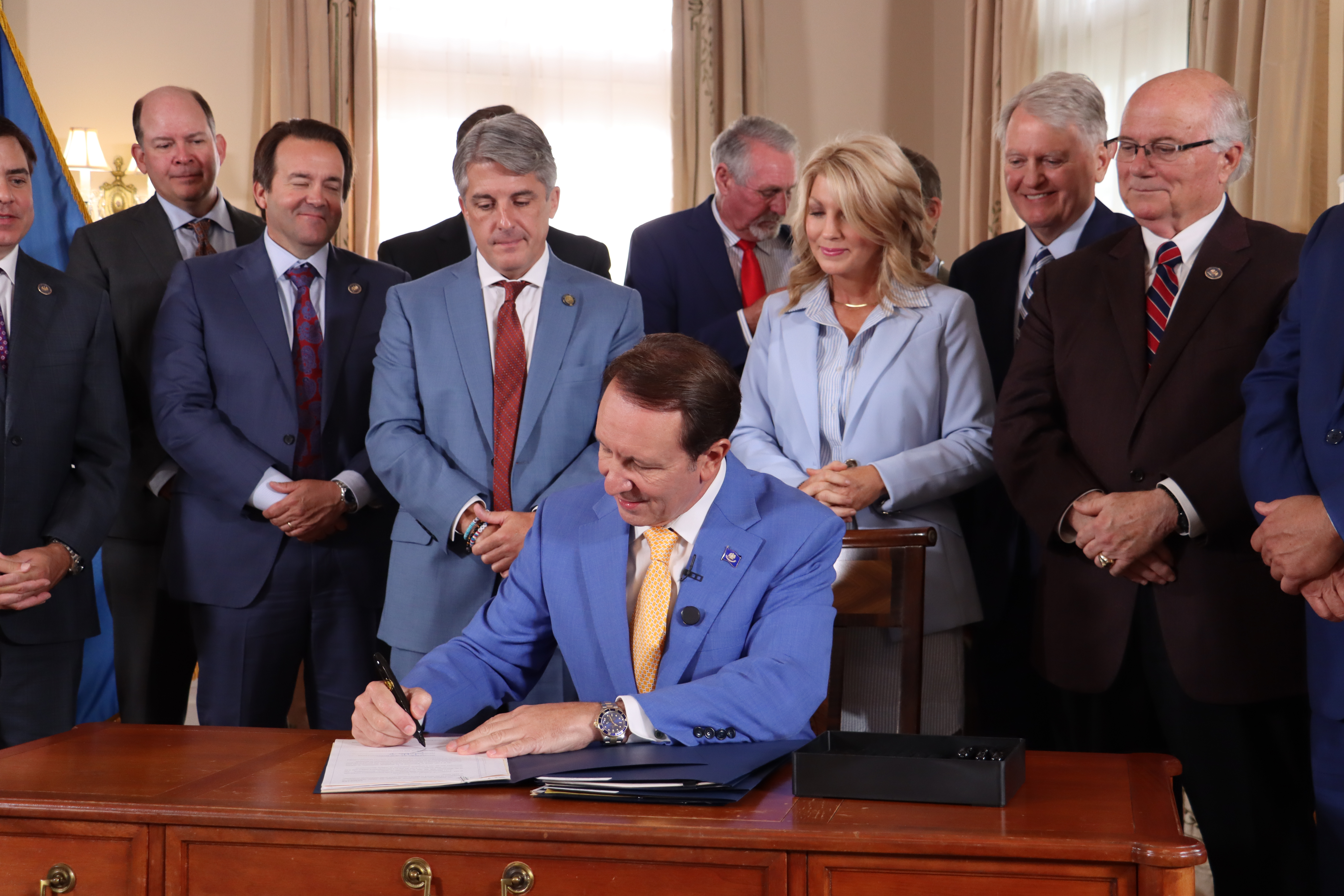 Photograph of Governor Landry signing documents