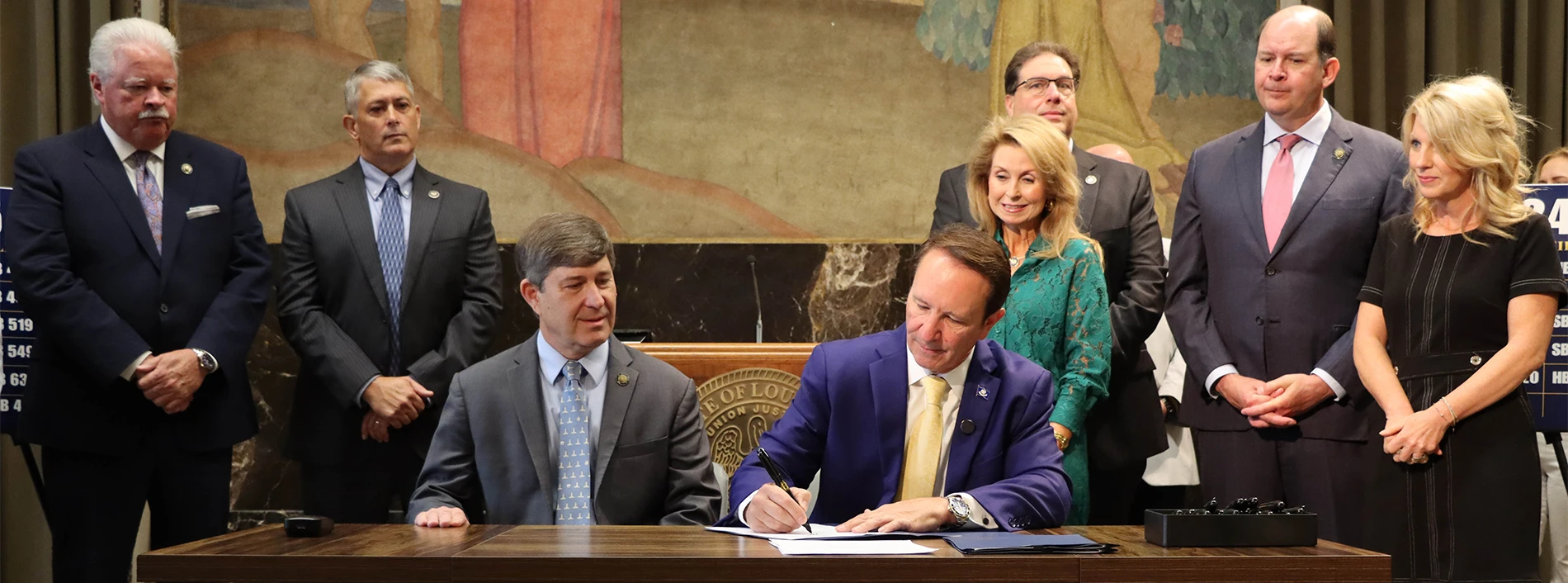 Photography of Governor Landry signing documents